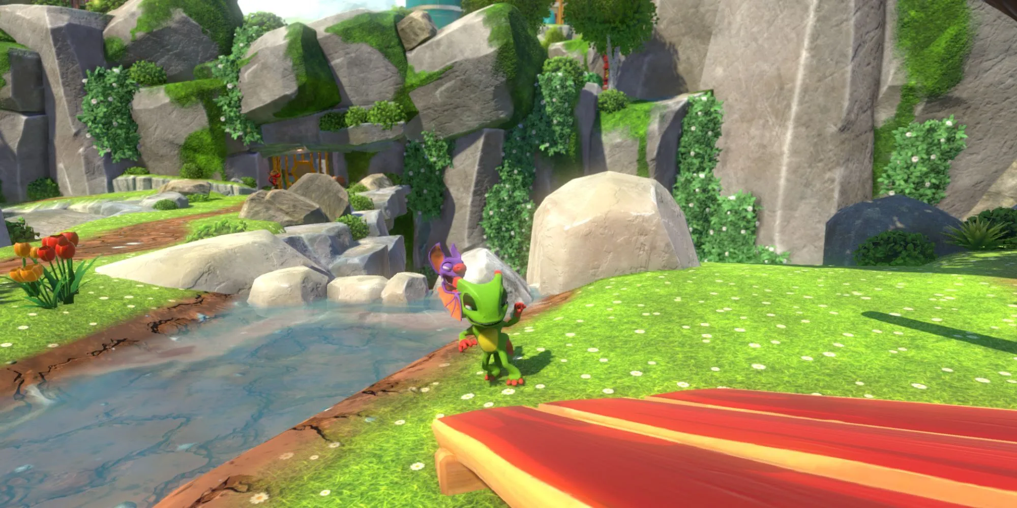 Bộ đôi Yooka và Laylee đứng cạnh bờ sông trong thế giới đầy màu sắc